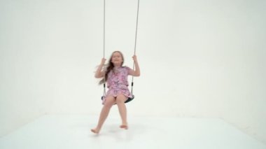 Şirin Mutlu Kız İpte Oturuyor Sallanıyor ve Yukarı Bakıyor