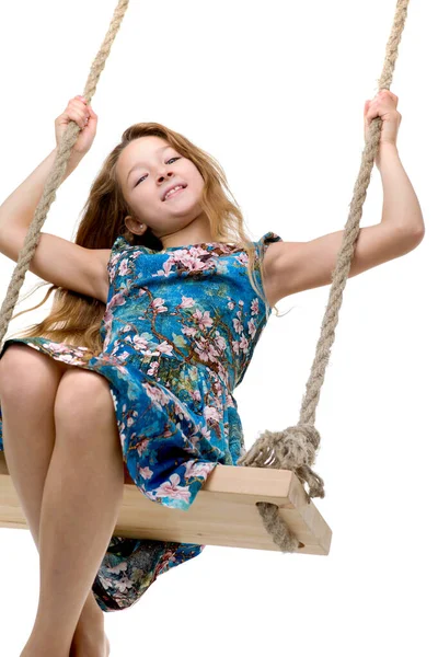 Menina loira balançando no balanço da corda — Fotografia de Stock