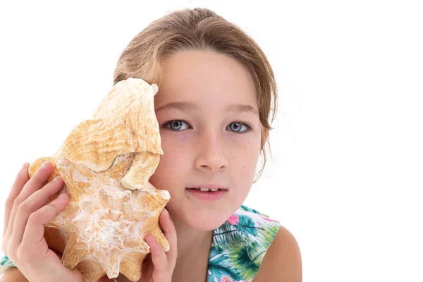 Happy little girl listen to seashell — Stockfoto