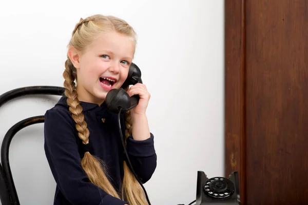 Blond flicka pratar med gamla svarta telefonen — Stockfoto