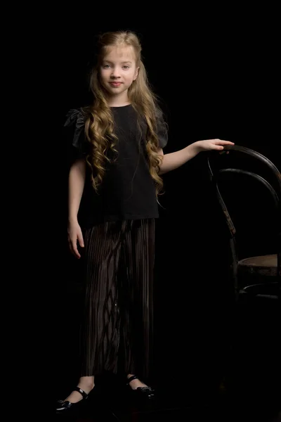 Retrato de uma menina que fica em um fundo preto perto do Vie — Fotografia de Stock