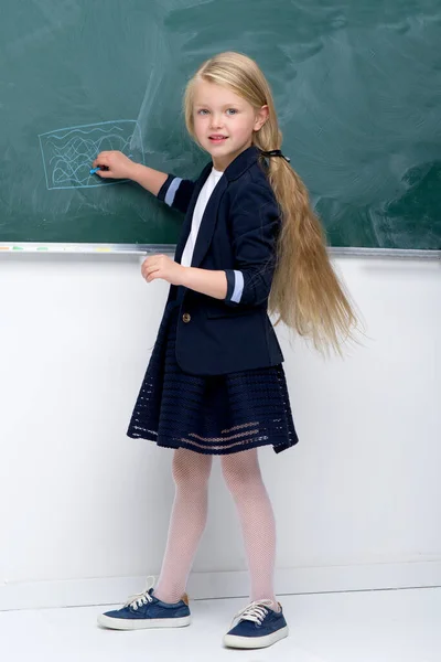 Schöne Schülerin steht an der Tafel — Stockfoto
