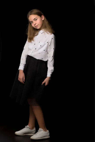 Fashionable girl teenager studio photo on a black background. — Stock Photo, Image