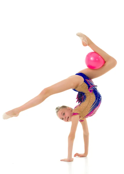 Flicka gymnast utför övningar med bollen. — Stockfoto