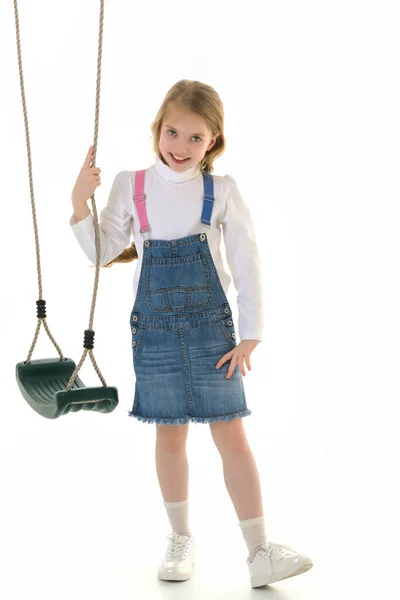 Cute little girl is standing near the swing. — Stock Photo, Image