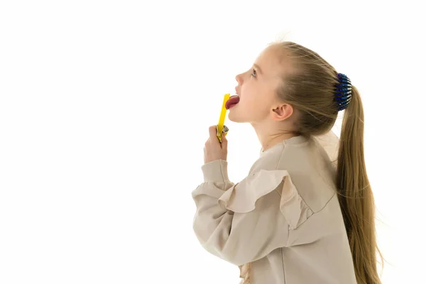 Nettes kleines Mädchen leckt ein Bonbon. — Stockfoto