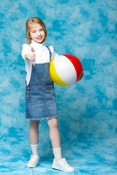 Маленька дівчинка грає з м'ячем. Концепція дитячого спорту, літній відпочинок на відкритому повітрі . — стокове фото