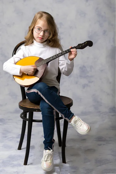 Schattig klein meisje speelt dombra. — Stockfoto