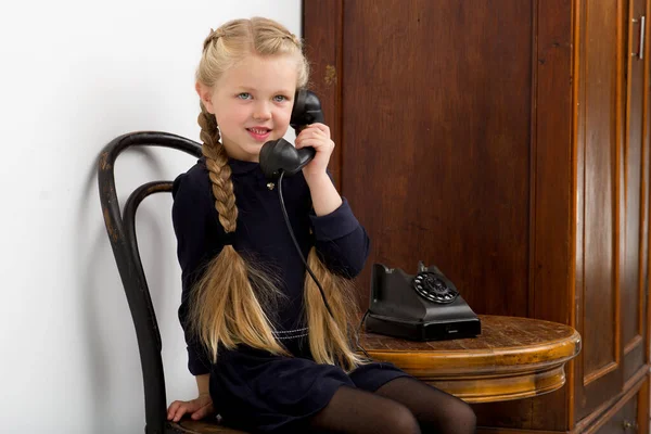 Blond flicka pratar med gamla svarta telefonen — Stockfoto