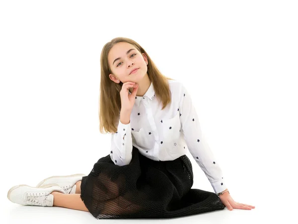 Adolescente posando no chão no estúdio. O conceito de estilo e moda. — Fotografia de Stock