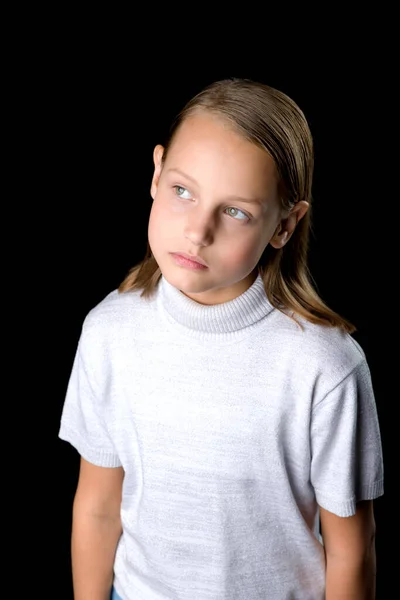 Vista de cerca de una linda niña sonriente posando sobre fondo negro. — Foto de Stock