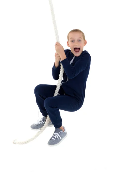 Aktywny uśmiechnięty chłopiec wiszący na huśtawce liny — Zdjęcie stockowe