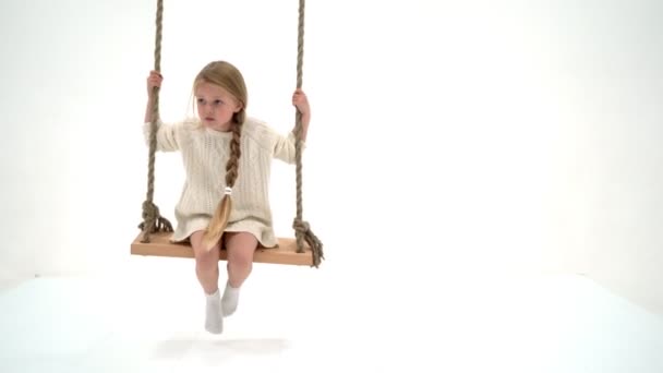 Cute long haired girl sitting on rope swing — Stock Video