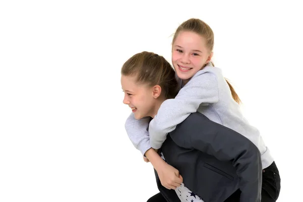 Feliz sorrindo adolescente menina porquinho apoiando sua irmã gêmea — Fotografia de Stock