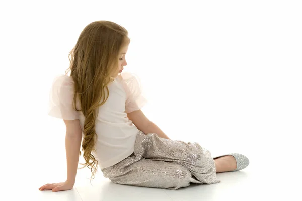 A menina está sentada no chão.O conceito de uma criança feliz — Fotografia de Stock