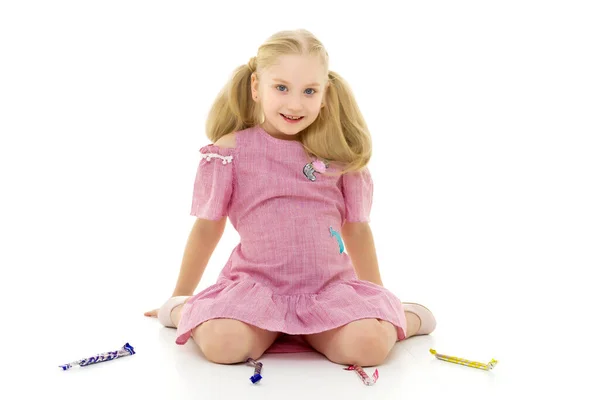 A menina é um dente doce, ela está muito feliz com os doces. — Fotografia de Stock