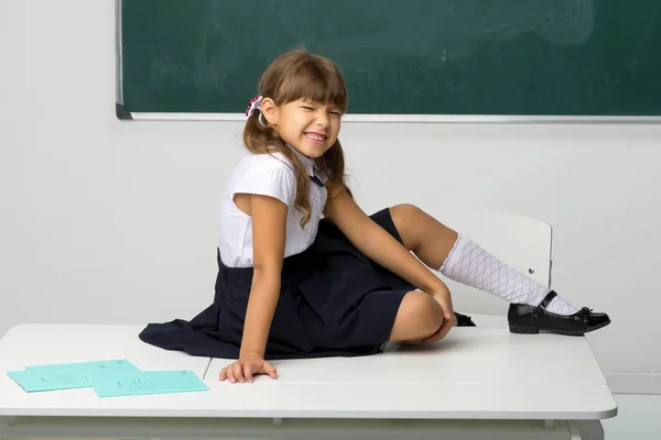 Menina da escola feliz sentado na mesa em sala de aula — Fotografia de Stock