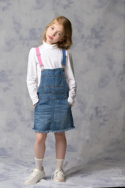 Bambina con un vestito corto di denim. — Foto Stock