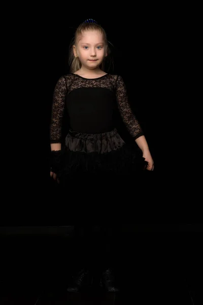 Милая маленькая девочка в красивом платье на черном фоне. — стоковое фото