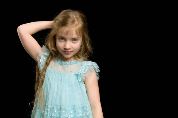 En vacker liten flicka rätar ut håret på huvudet. — Stockfoto