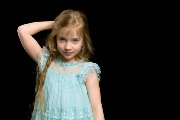 Uma linda menina endireita o cabelo na cabeça. — Fotografia de Stock