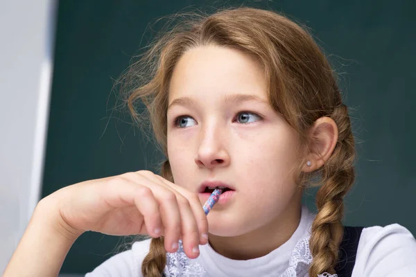 Porträtt av pensiv skolflicka.Tillbaka till skolan, utbildningskoncept — Stockfoto