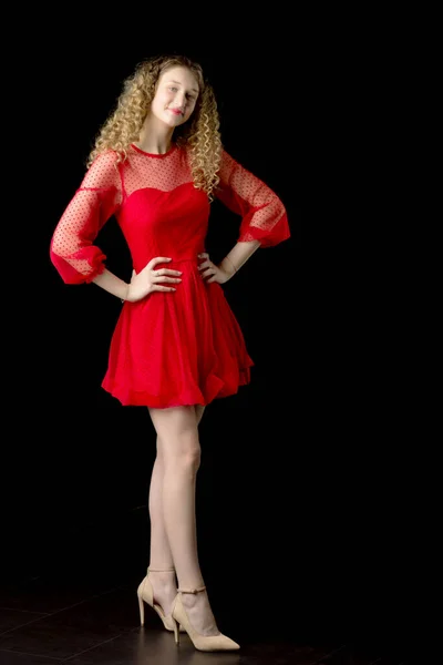 Kırmızı elbiseli gülümseyen kıvırcık kız. — Stok fotoğraf