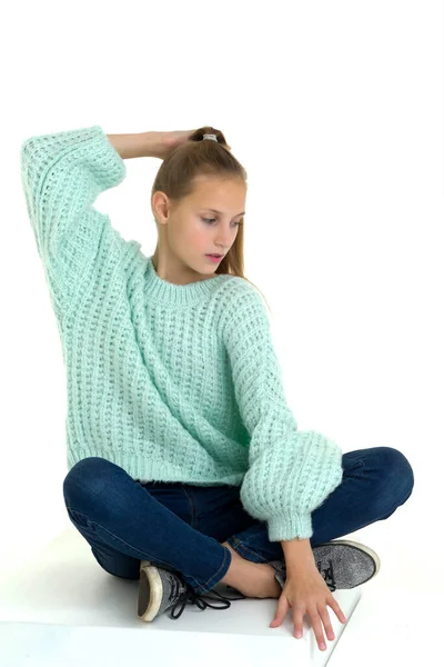Nastolatka siedzi na podłodze ze skrzyżowanymi nogami — Zdjęcie stockowe