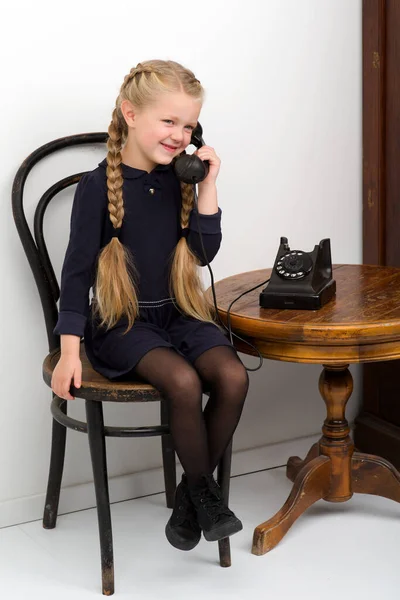 Menina loira falando por telefone preto velho — Fotografia de Stock