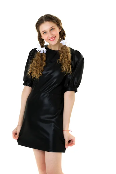 Cheerful teen girl holding hem of her black dress — Stock Photo, Image