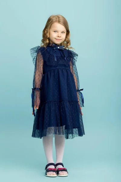 Mooi klein meisje poseren in mooie blauwe jurk — Stockfoto
