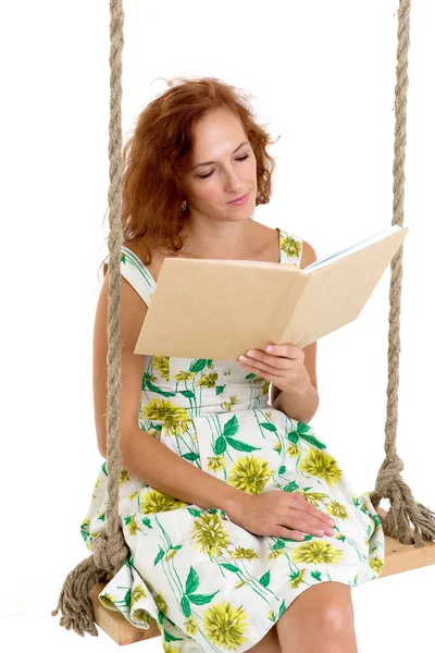 Mutlu genç kadın salıncakta kitap okuyor. — Stok fotoğraf