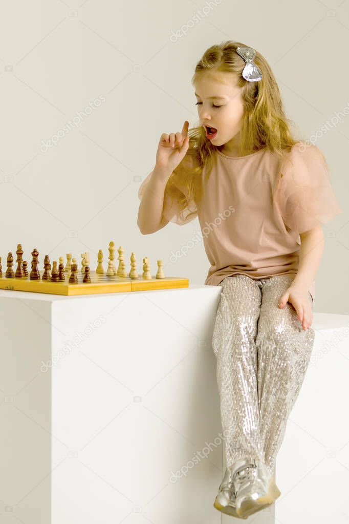 Little girl playing chess.Creative education of a child.