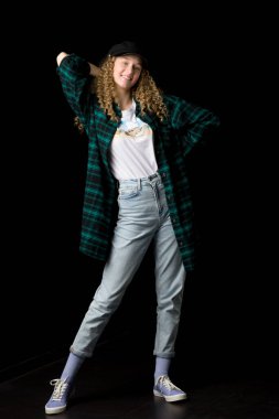 Tarz sahibi kız, gülümseyen kamera, elinin arkasında.