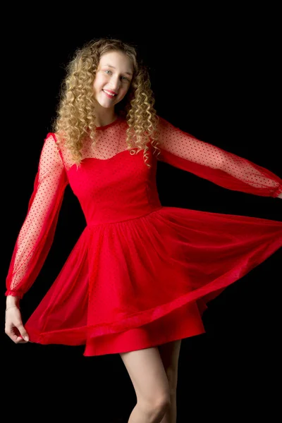 Neşeli, gülümseyen sarışın kız kırmızı elbiseyi kaldırıyor. — Stok fotoğraf