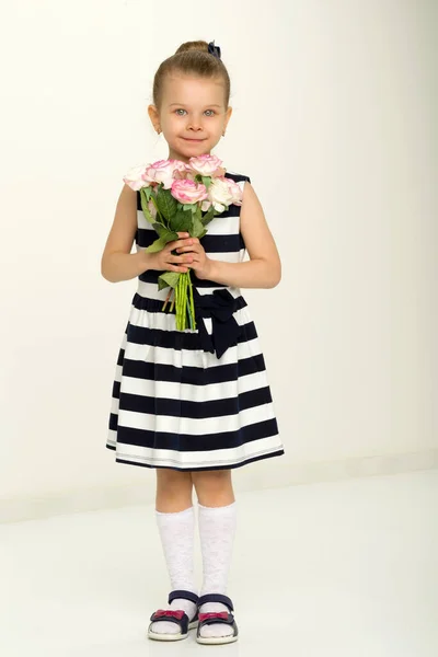 Schattig klein meisje staan met boeket bloemen — Stockfoto