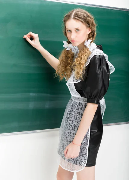 Shot of angry school girl standing at blackboard — Stock Photo, Image