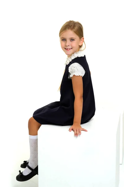 Чарівна маленька дівчинка сидить на білому кубі — стокове фото