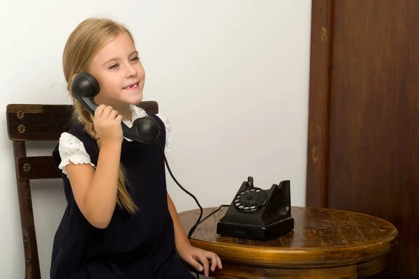 Cute blonde girl talking on vintage telephone