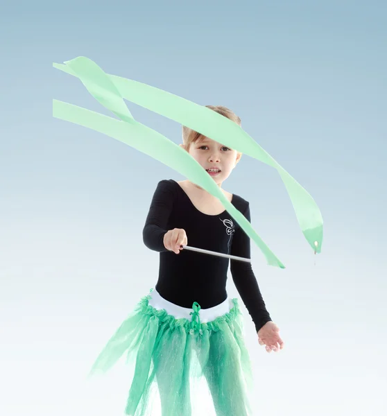 Little girl performs gymnastic exercises with a ribbon. — Stock Photo, Image