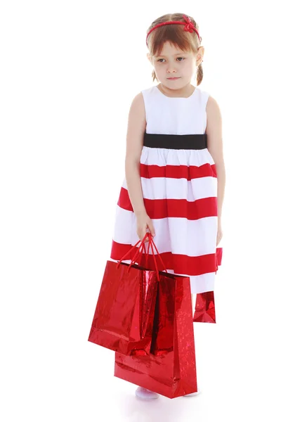 Adorable niña con bolsas de papel rojo — Foto de Stock