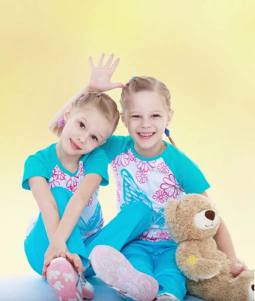 Twin sisters hugging her favorite teddy bear. — Stock Photo, Image