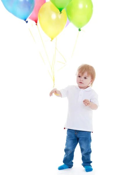 Petit garçon tenant des ballons sur un fond blanc. — Stockfoto