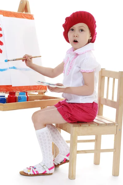 Dívka v červený baret sedí na stojan — Stock fotografie