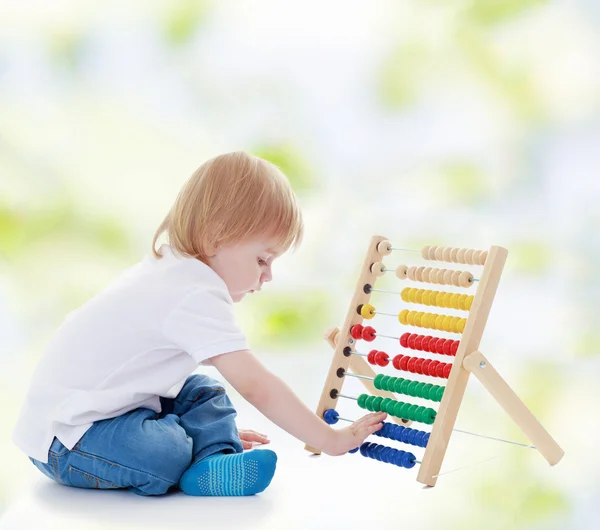 Little boy is counting on the abacus. — Stock Photo, Image
