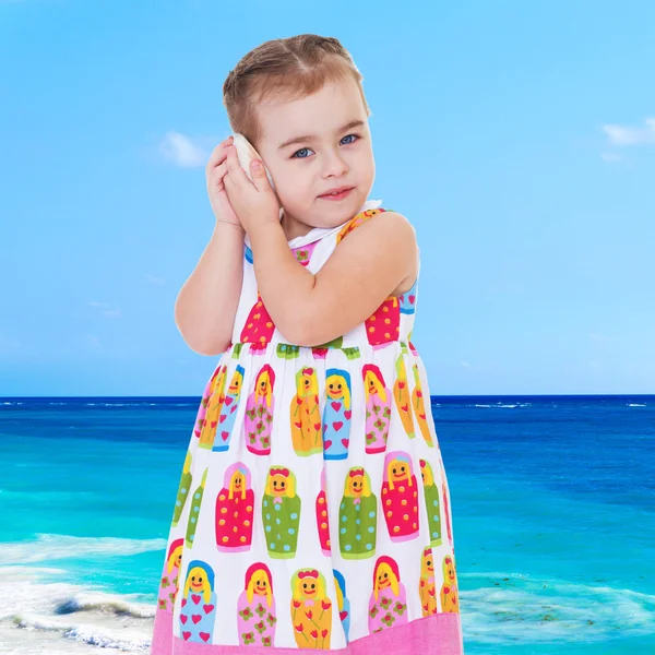 Charming girl on the beach listening to a noise shell attaching — Stock Photo, Image