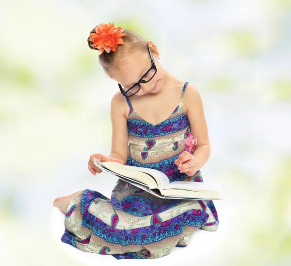 The little girl in big glasses reading a book — Stock Photo, Image