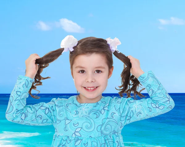 Cheerful charming girl tugged at his braids while on holiday — Stock Photo, Image