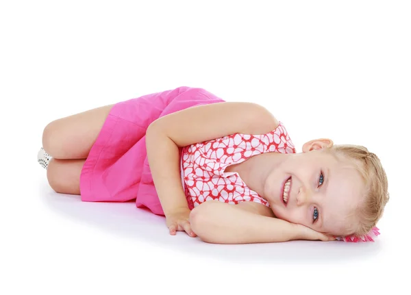 Yerde yatarken gülümseyen sevimli küçük kız — Stok fotoğraf