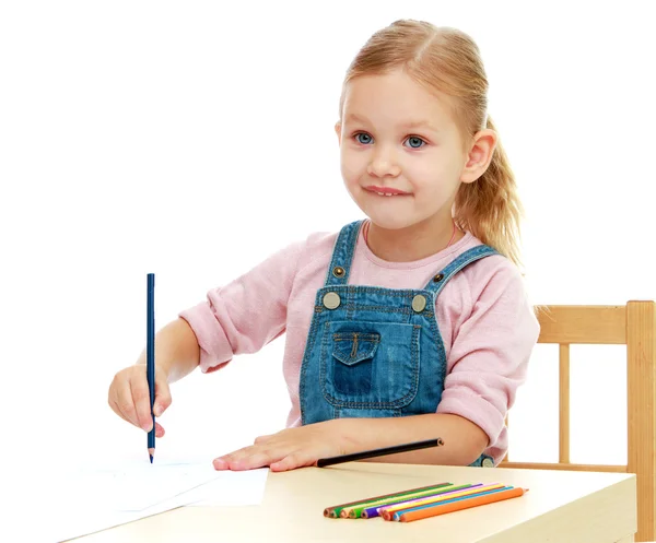 Menina desenha lápis sentado à mesa . — Fotografia de Stock